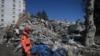 Спасувач стои пред урнатините во близина на урната зграда, 248 часа по земјотресот со јачина од 7,8 степени според Рихтеровата скала што ги погоди делови од Турција и Сирија, во Кахраманмарас на 16 февруари 2023 година.