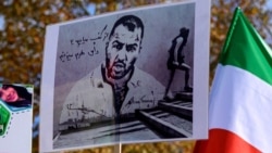 Protesters hold placards bearing portraits of then-detained Iranian rapper Toomaj Salehi and portraits of children (left) who were killed during the protests in Iran. (file photo)