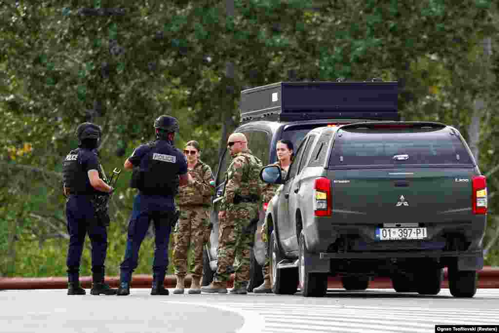 Pjesëtarë të KFOR-it dhe policë të Kosovës duke biseduar në një rrugë afër Banjskës.