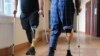 Ushtarët e plagosur ukrainas me këmbë protetike ecin me paterica në një qendër rehabilitimi afër Lvivit në Ukrainën perëndimore. 22 shkurt 2023.