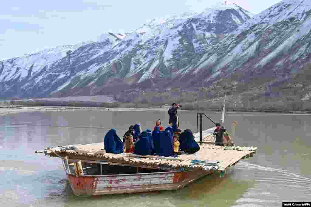 Afghan women with their children sit on a boat to cross the Kokcha River in the Yaftal Sufla district of Badakhshan Province.