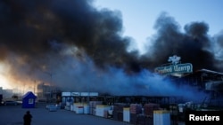 Рятувальники ліквідовують пожежу в будівельному гіпермаркеті в Харкові після російського удару, 25 травня 2024 року
