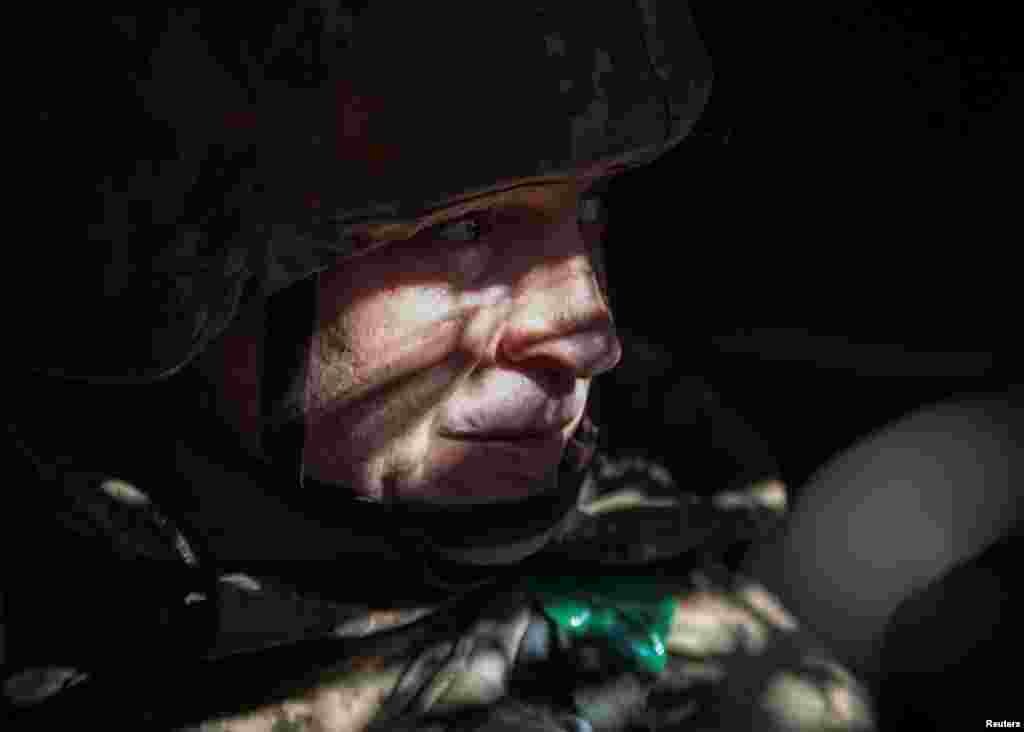 A Ukrainian service member looks on in a trench at a position on a front line near the city of Bakhmut