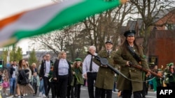 Republikanci u starinskim kostimima marširaju u zapadnom Belfastu u Sjevernoj Irskoj dok obilježavaju 106. godišnjicu Uskršnjeg ustanka