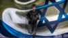 Shira, një sulmuese izraelite e lindur në Kaliforni nga Batalioni Bardelas, i cili shërbeu në Rripin e Gazës në mes të konfliktit të vazhdueshëm në Gaza mes Izraelit dhe grupit radikal palestinez Hamas - i shpallur organizatë terroriste nga Shtetet e Bashkuara dhe Bashkimi Evropian - qëndron mbështetur në një mur pranë kufirit të Izraelit me Egjiptin, më 21 shkurt. 2024.<br />
<br />
Izraeli është një nga vendet e pakta në botë ku shërbimi ushtarak është i detyrueshëm për gratë që nga mosha 18 vjeç.
