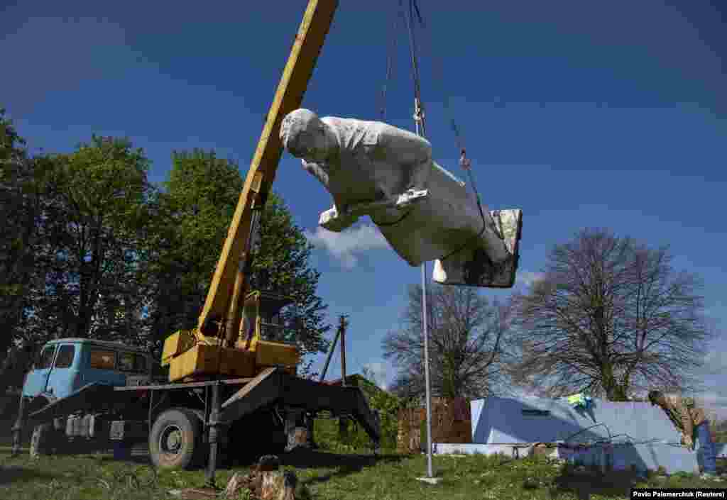 Workers dismantle a Soviet World War II victory monument in the Ukrainian village of Cherneve in the Lviv region.