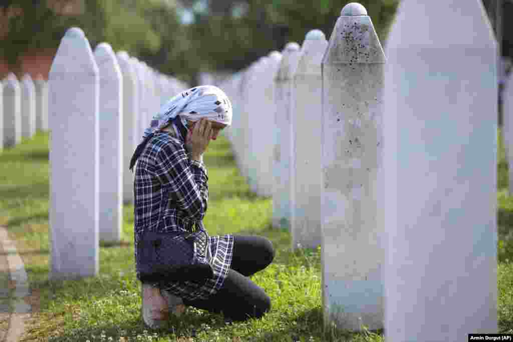 A Bosnian Muslim woman mourns next to the grave of a relative during the commemoration ceremony. Many Serbs deny the extent of the killings, adding to the suffering of the survivors. Bosnian Serb leader Milorad Dodik has previously called the genocide &quot;a fabricated myth.&quot;