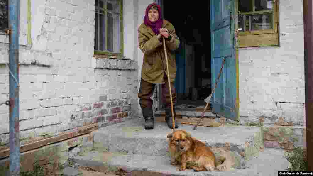 Yevdokia Beznoshchenko, 78, waits in front of her home in the Chernobyl Exclusion Zone in northern Ukraine on October 18. The nuclear accident that occurred on April 26, 1986, in Chernobyl, Ukraine, contaminated roughly 150,000 square kilometers of land in Belarus, Russia, and Ukraine and forced nearly 200,000 people from their homes.