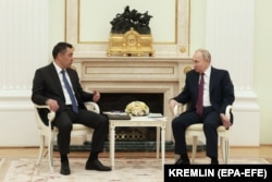 Russian President Vladimir Putin (right) speaks with Kyrgyz President Sadyr Japarov during a meeting at the Kremlin on May 8.