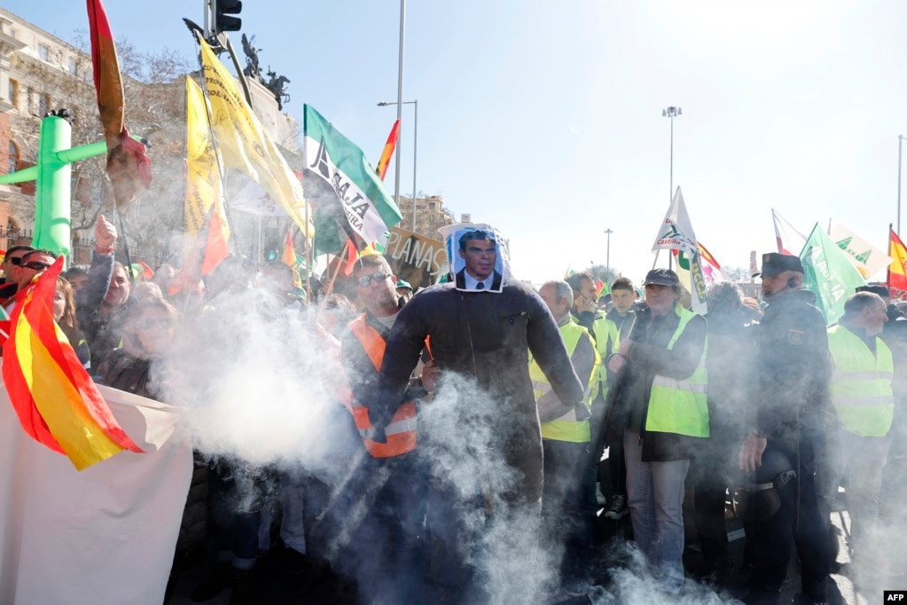 Një burrë mban një portret të kryeministrit spanjoll, Pedro Sanchez, mbi fytyrën e tij derisa fermerët protestonin kundër kushteve të punës dhe politikave evropiane për bujqësinë, Madrid, më 26 shkurt 2024.