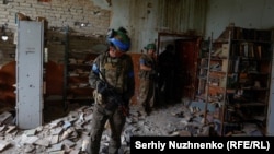 Elesett orosz katona a visszafoglalt Blahodatne falu egykori könyvtárában 2023. június 17-én