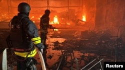 Ukrainian firefighters battle a blaze at a shopping mall hit by a Russian air strike in Kharkiv on May 25.