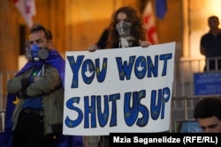 Një vajzë e re duke e mbajtur në dorë një pankartë: "Nuk mund të na e mbyllni gojën", gjatë një proteste në Tbilisi kundër projektligjit "agjentët e huaj", 1 maj.