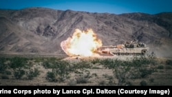 An M1A1 Abrams tank fires its 120 mm cannon at a training ground in California.