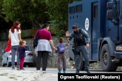 Një oficer i Policisë së Kosovës duke përshëndetur një fëmijë në fshatin Banjskë, të mërkurën më 27 shtator 2023.