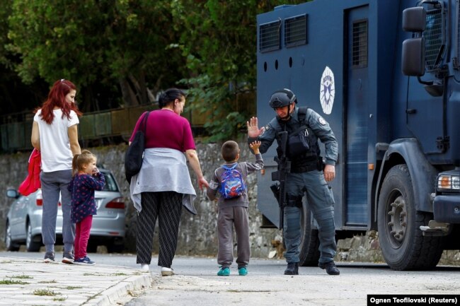 Një oficer i Policisë së Kosovës duke përshëndetur një fëmijë në fshatin Banjskë, të mërkurën më 27 shtator 2023.