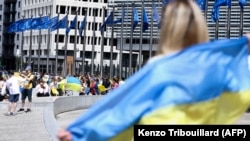 Fotografie din timpul unui protest din 2022, în care manifestanții au format un lanț uman în jurul sediului Comisiei Europene pentru a susține cererea Ucrainei de obținere a statutului de candidată la UE, la Bruxelles.