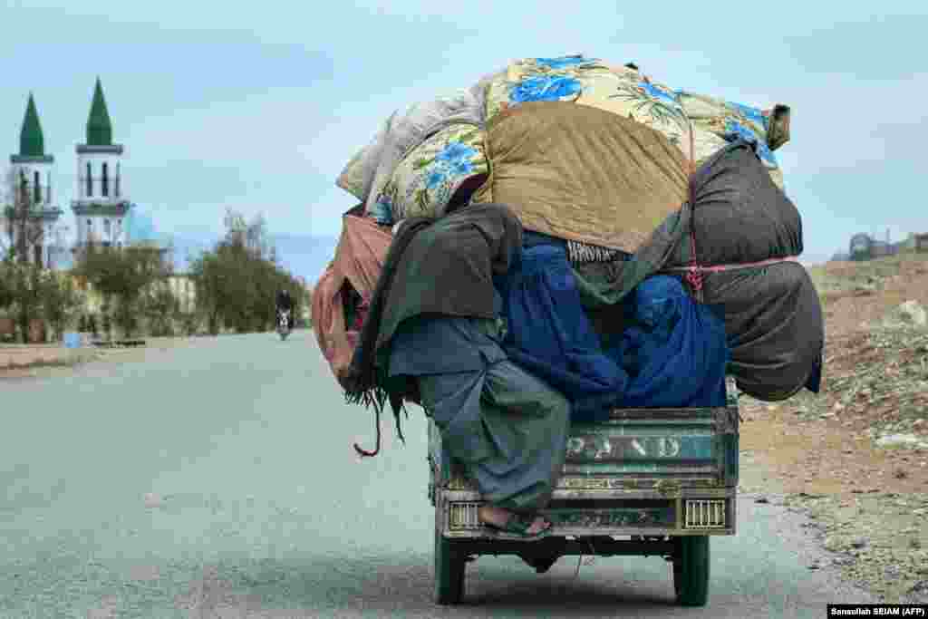 An Afghan man and two women ride a three-wheeled vehicle in the Arghandab district of Kandahar Province.