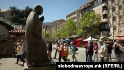 Turisti uživaju u suncu u Skoplju u blizini statue Majke Tereze, jednog od 280 kipova razasutih po glavnom gradu, april 2024.
