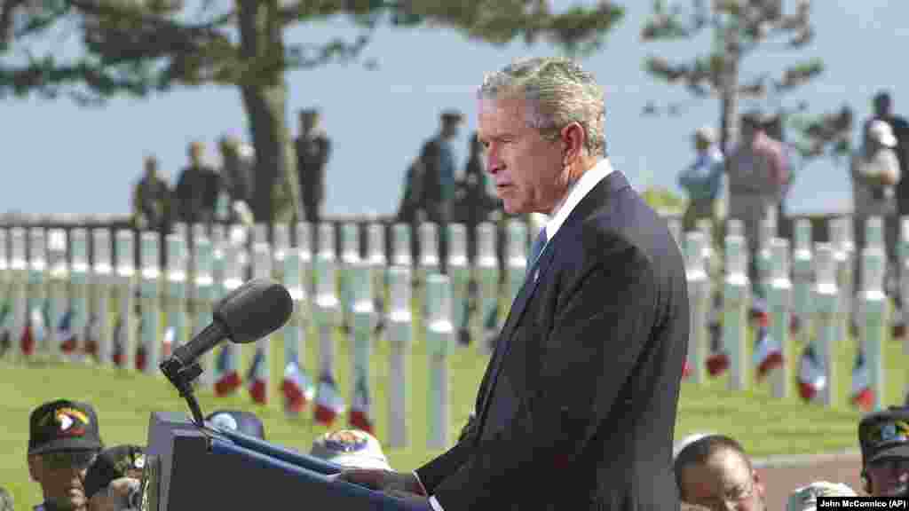 Američki predsjednik George W. Bush drži govor na američkom groblju u Normandiji tokom 60. godišnjice Dana D 6. juna 2004. Ovo je ujedno bio i prvi put da je ruski predsjednik Vladimir Putin pozvan na komemoracije, gdje je istakao žrtve Sovjetskog Saveza.
