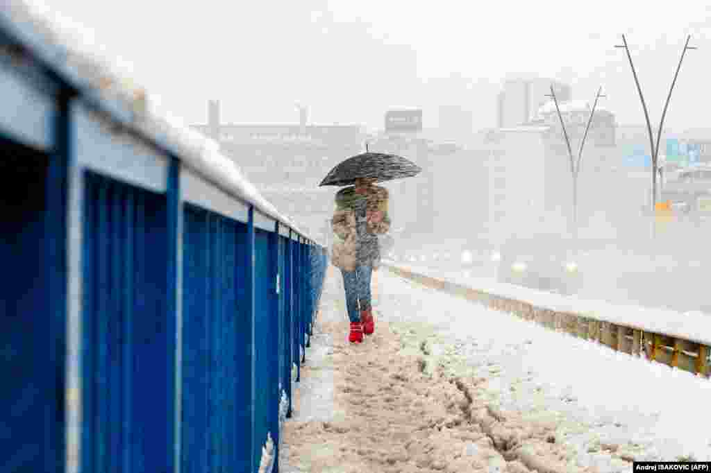 A woman walks on a bridge in snowy weather in Belgrade, Serbia.&nbsp;