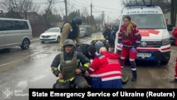 Парамедики надають допомогу пораненим рятувальникам на місці російського ракетного удару під час атаки Росії на Україну, в Одесі, Україна, 15 березня 2024 року.