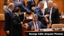 Premierul român Marcel Ciolacu, înconjurat de o parte din miniștrii cabinetului său și de alți colegi din Parlament. 