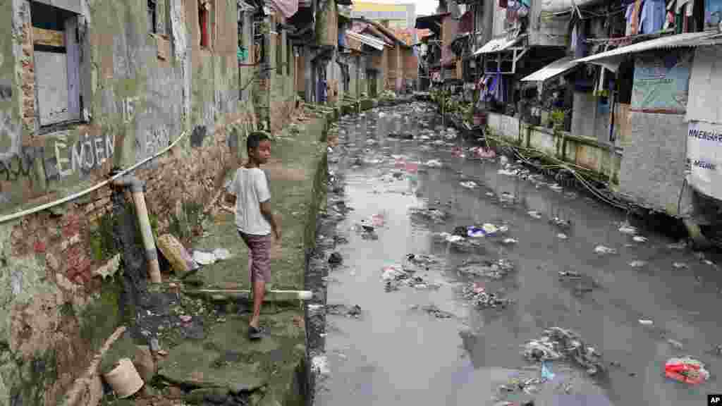 Szennyezett városi csatorna Jakartában 2024. március 13-án. Jáva szigetén az éghajlatváltozás miatt hosszabb száraz és csapadékosabb esős évszakok alakultak ki. A túlnépesedés &ndash; Jakarta a világ egyik legsűrűbben lakott városa &ndash;, a vízgyűjtő infrastruktúra hiánya és számos további rendszerszintű probléma egyre súlyosbodó vízkrízishez vezet. A tengerszint emelkedése és a földsüllyedés miatt Jakarta folyamatosan süllyed