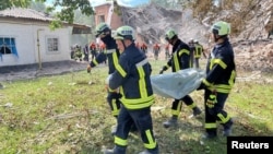 Rescuers remove a body at the site of a Russian missile strike in Romny on August 23.