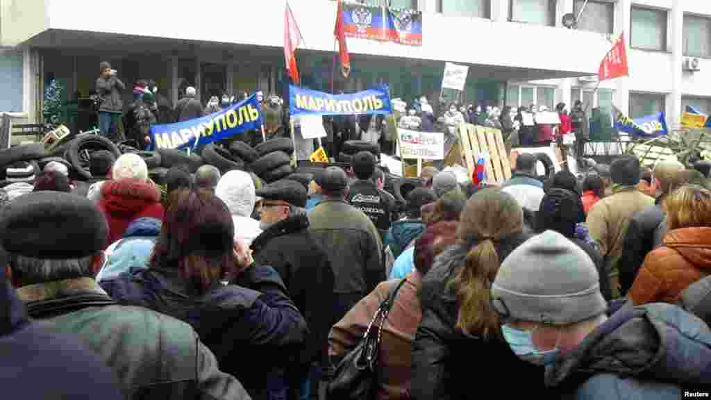 Tömeg gyűlik össze 2014. április 13-án a mariupoli tanács épülete előtt, miután oroszbarát aktivisták elfoglalták. Ukrajna nagyrészt oroszok lakta Donbász régiójában zűrzavarossá vált a helyzet, miután 2014 februárjában megbuktatták Viktor Janukovics oroszbarát ukrán elnököt