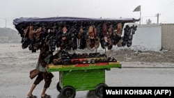 باران های موسمی در کابل. یک بوت فروش سیار در حالیکه باران به شدت می بارد در یکی از سرک های کابل دیده می شود