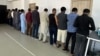 Pakistanis arrested for illegally working in Kyrgyzstan are lined up by police in Bishkek on May 15.