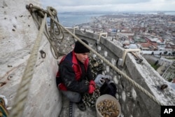 Zanatlija Cemil Buyurkan na vrhu munare džamije Sulejmanije, Istanbul, 6. marta 2024.