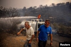 Lokalni vatrogasci i mještani u borbi protiv požara u Mandri, Grčka, 18. juli 2023.