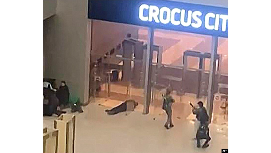 Această imagine capturată dintr-un film obținut de AFP TV arată oameni înarmați neidentificați îndreptându-se spre ușile Primăriei Crocus din Krasnogorsk, în afara Moscovei, la sfârșitul zilei de 22 martie 2024.