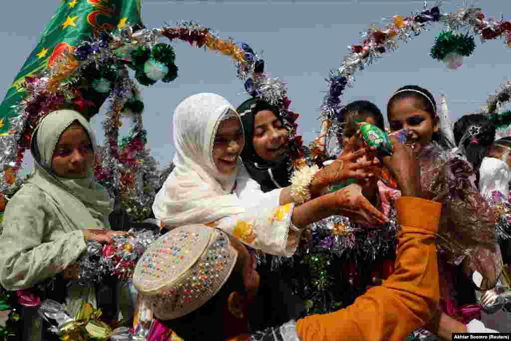 Girls reach out to collect snacks during celebrations to mark the birth anniversary of the Prophet Muhammad in Karachi, Pakistan, on September 29.