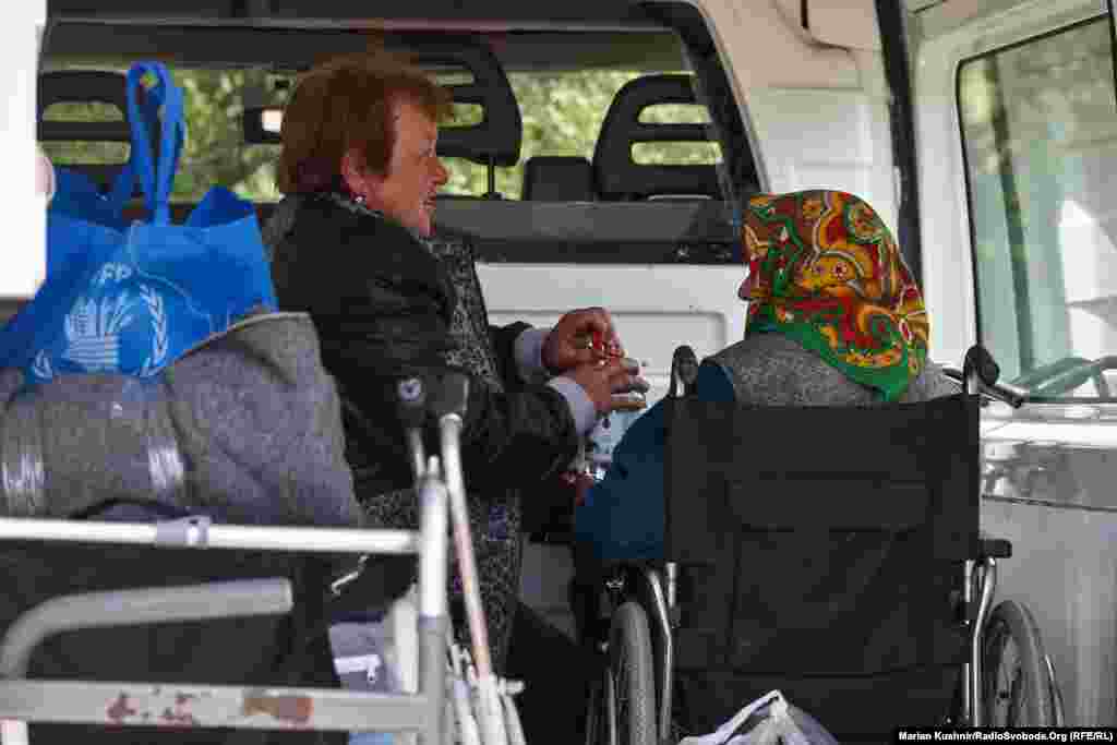 Alla and her mother sit in a minibus waiting to be evacuated. Alla says she hopes to return home soon.