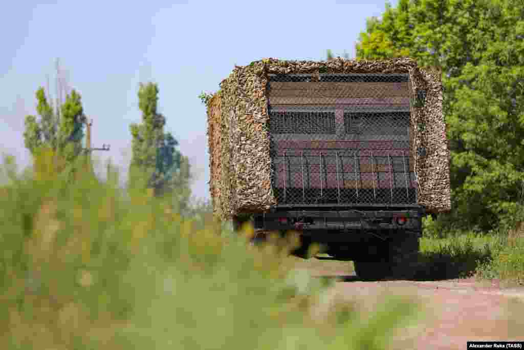 A Russian military vehicle fitted with makeshift wooden armor, netting, and apparent side armor to protect against FPV drones is seen in Ukraine&#39;s Luhansk region in June. &nbsp;