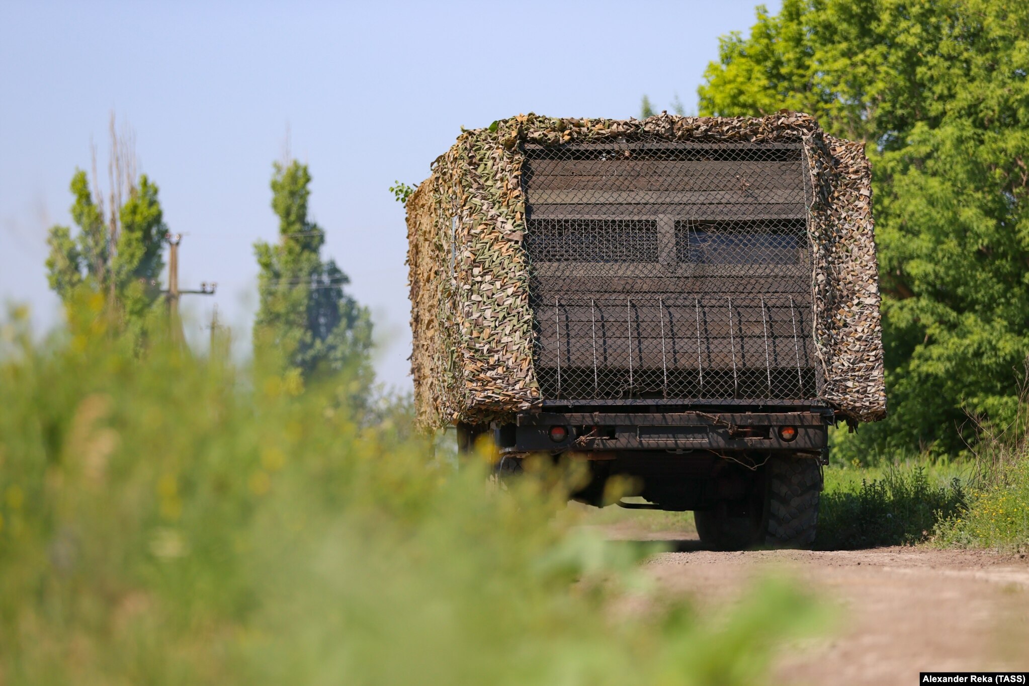 A Russian military vehicle fitted with makeshift wooden armor, netting, and apparent side armor to protect against FPV drones is seen in Ukraine's Luhansk region in June. 