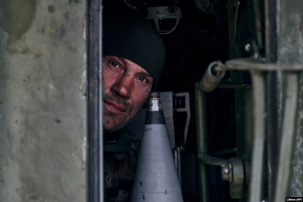 Një ushtar ukrainas duke shikuar nga një obus vetëlëvizës.