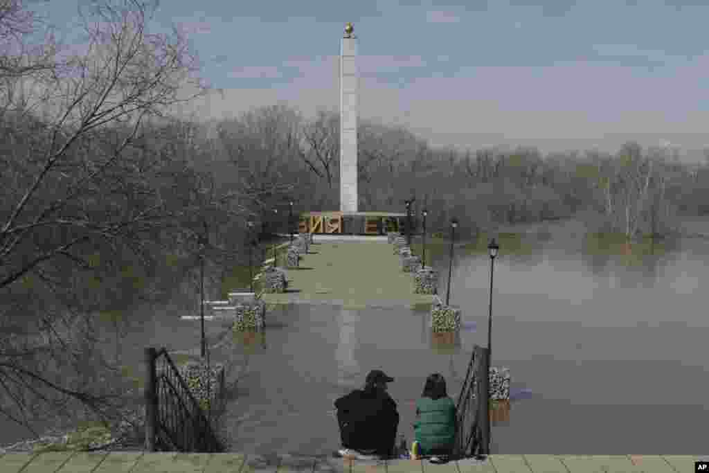 A couple in Orenburg, Russia, observe the floodwaters surrounding the Europe-Asia Monument, which denotes the border between Europe and Asia. &quot;Difficult days are still ahead,&quot; Kremlin spokesman Dmitry Peskov told reporters in Moscow on April 9. &quot;There is a lot of water coming.&quot; &nbsp;