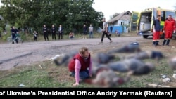 Një grua reagon pranë trupave të vrarë dhe plagosur në zonën e sulmit rus në fshatin Hroza, në rajonin Harkiv, në Ukrainë, 5 tetor 2023.