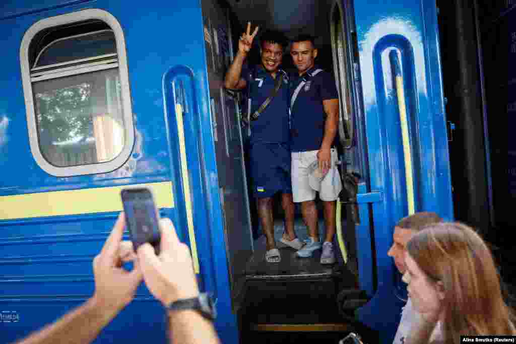 A gold medallist at the 2020 Tokyo Olympics and a member of the Ukrainian Olympic wrestling team, Zhan Belenyuk (left), and teammate Parviz Nasibov say goodbye to friends and families as they board a train to the Paris 2024 Olympics in Kyiv on July 23.