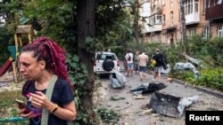 Lokalno stanovništvo u blizini svoje stambene zgrade oštećene tokom ruskog raketnog udara, u Kijevu, 30. avgusta 2023.