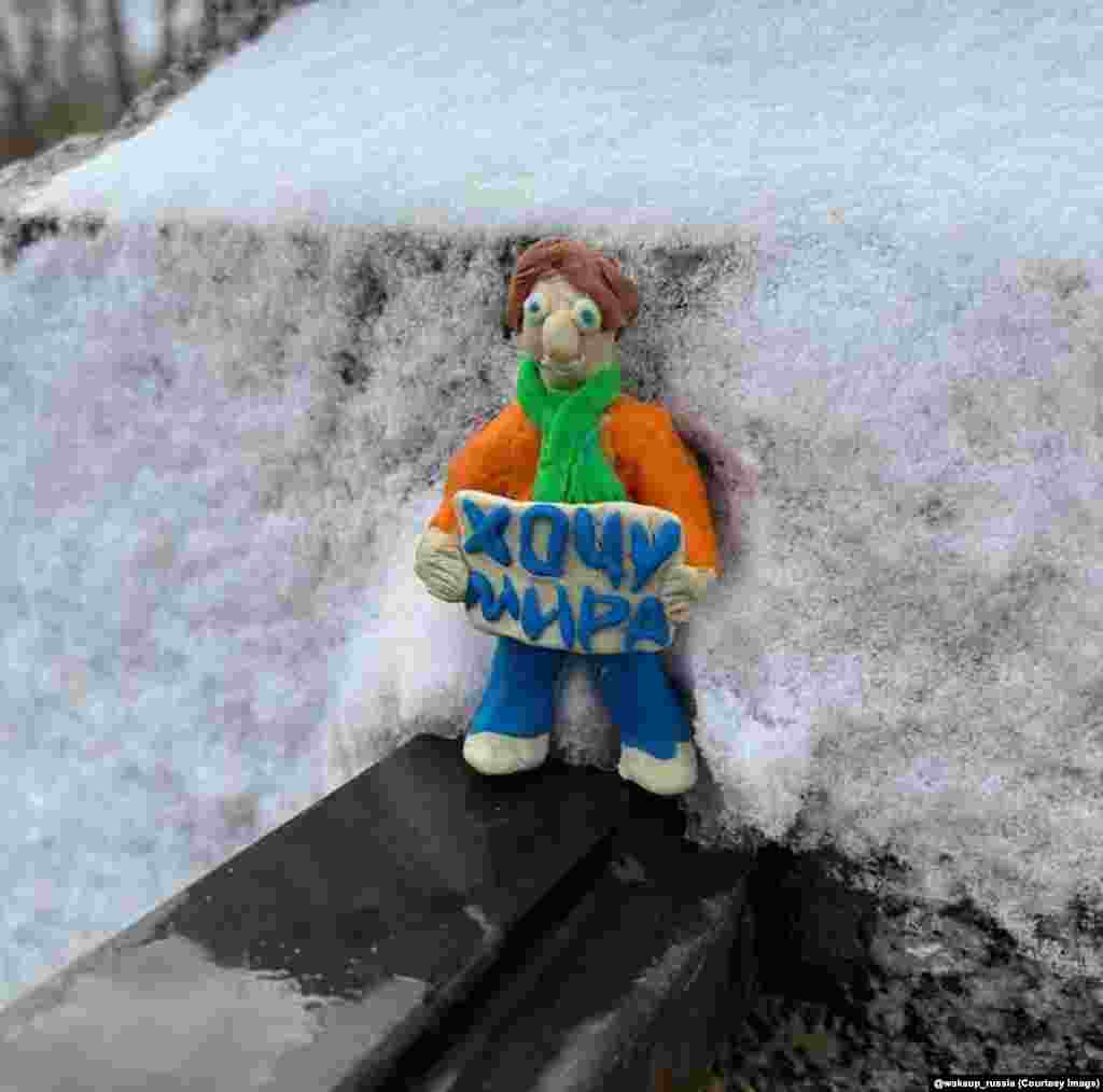 A tiny figure holding a sign saying &ldquo;I want peace&rdquo; in St. Petersburg. &nbsp;