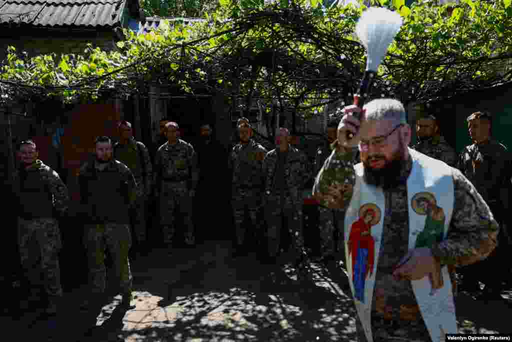 Військовий капелан Олександр Карапетян окроплює свяченою водою військовослужбовців 93-ї окремої механізованої бригади&nbsp;&laquo;Холодний Яр&raquo; під час Великодного богослужіння поблизу лінії фронту. Донецька область, 5 травня 2024 року&nbsp;