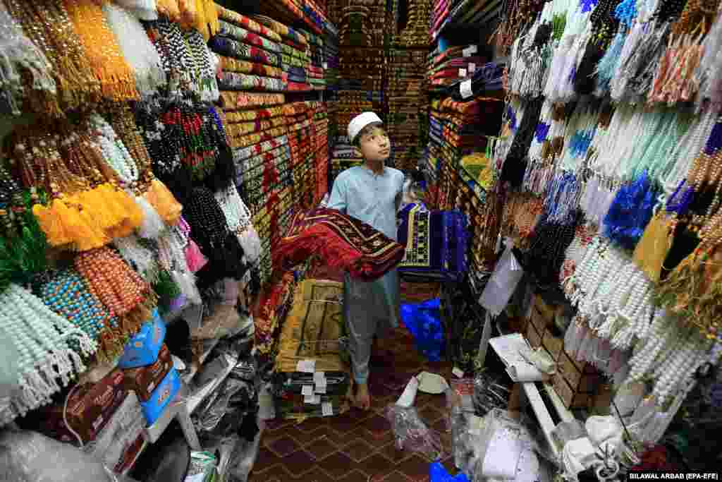 A vendor sells prayer mats at a shop ahead of the Muslim holy month of Ramadan in Peshawar, Pakistan.&nbsp;