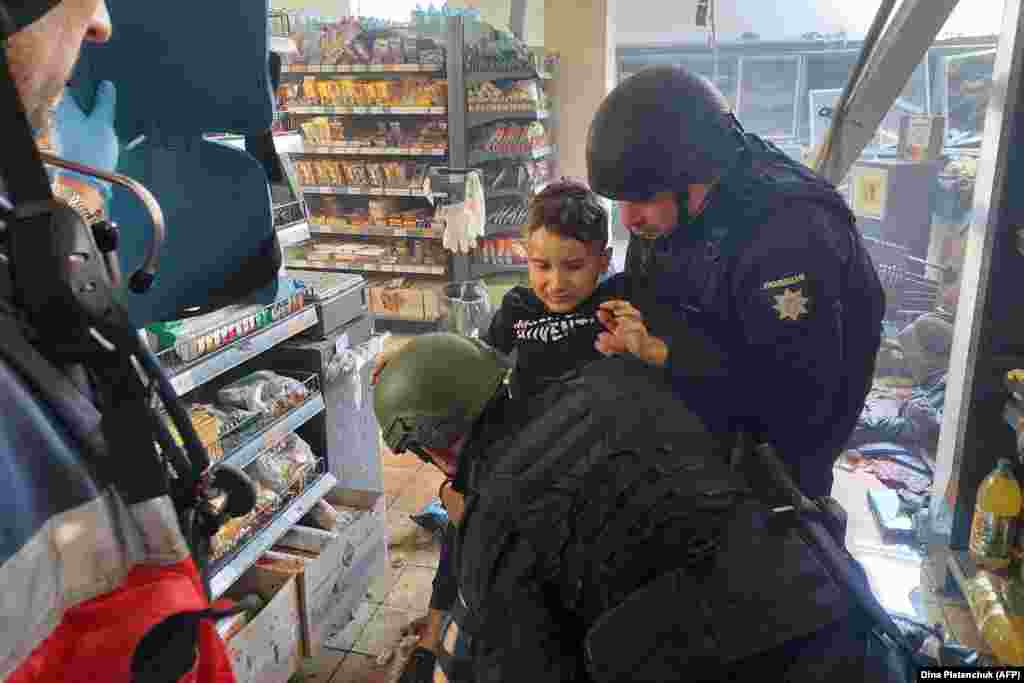 Поліцейські надають допомогу пораненій дитині після російського удару по Херсону 3 травня 2023 року