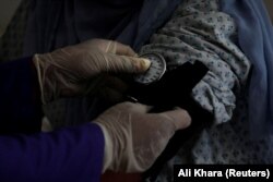 A trainee midwife examines a woman in a hospital in Bamiyan.