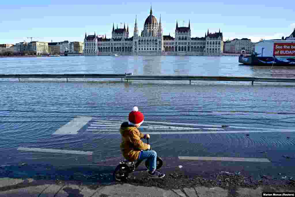 A child rides his bike along the Danube as floodwaters engulf a quay in Budapest on December 27. According to the North Transdanubian Water Directorate, almost 1,200 kilometers along the river in Hungary are under a flood alert due to the recent high precipitation.